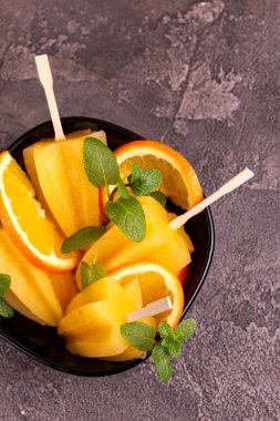 Gri beton zemin üzerine olgun turuncu ve taze nane ile ev yapımı turuncu buzlu şeker. Sağlıklı tatlılar. Laktoz ücretsiz dondurma.