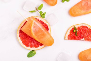 Ev yapımı greyfurt olgun greyfurt dilim ve ışık mermer zemin üzerine taze nane ile buzlu şeker. Sağlıklı tatlılar. Laktoz ücretsiz dondurma.