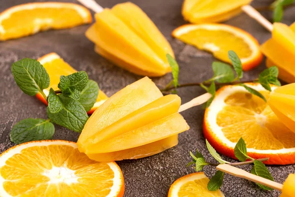 Gri beton zemin üzerine olgun turuncu ve taze nane ile ev yapımı turuncu buzlu şeker. Sağlıklı tatlılar. Laktoz ücretsiz dondurma.