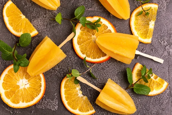 Gri beton zemin üzerine olgun turuncu ve taze nane ile ev yapımı turuncu buzlu şeker. Sağlıklı tatlılar. Laktoz ücretsiz dondurma.