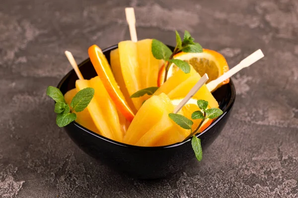 Gri beton zemin üzerine olgun turuncu ve taze nane ile ev yapımı turuncu buzlu şeker. Sağlıklı tatlılar. Laktoz ücretsiz dondurma.