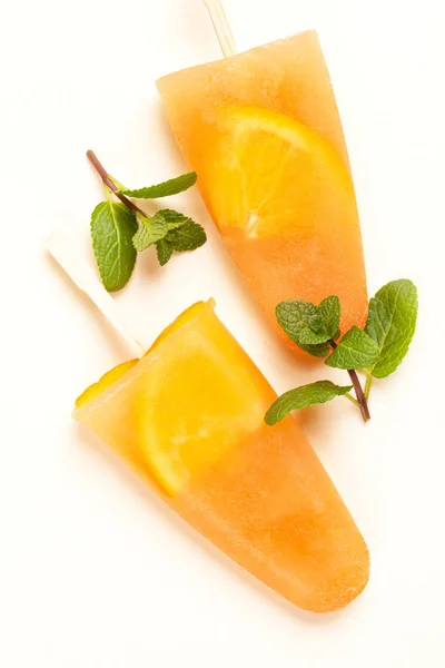 Homemade orange sorbet with orange slices inside and fresh mint. Light yellow background. Healthy desserts. Lactose free ice cream. Copy space