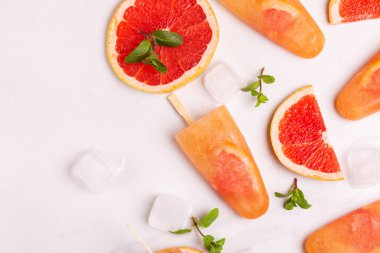 Ev yapımı greyfurt olgun greyfurt dilim ve ışık mermer zemin üzerine taze nane ile buzlu şeker. Sağlıklı tatlılar. Laktoz ücretsiz dondurma.