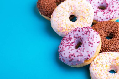 Parlak mavi zemin üzerine çeşitli lezzetli çörekler. Sağlıksız, ama lezzetli tatlılar. Kopya alanı