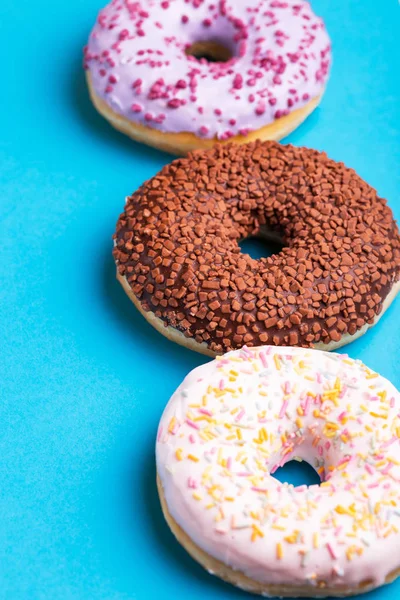 Tre Smaker Munkar Bär Choklad Och Vanilj Ljusa Blå Bakgrund — Stockfoto