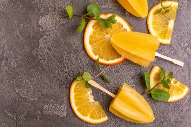 Gri beton zemin üzerine olgun turuncu ve taze nane ile ev yapımı turuncu buzlu şeker. Sağlıklı tatlılar. Laktoz ücretsiz dondurma.