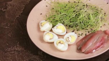 Pırasa lahanası, bıldırcın yumurtası ve hamsi plaka karanlık beton zemin üzerine alışılmadık salatası