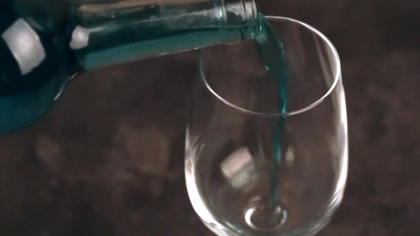 Verre et bouteille de vin bleu tendance. Chardonnay espagnol vin bleu sur fond béton foncé. Date romantique 