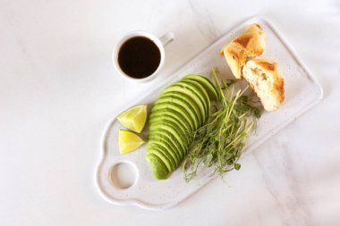 Avokado, topuz, bezelye filizi, limon, pesto ve kahve ile kahvaltı