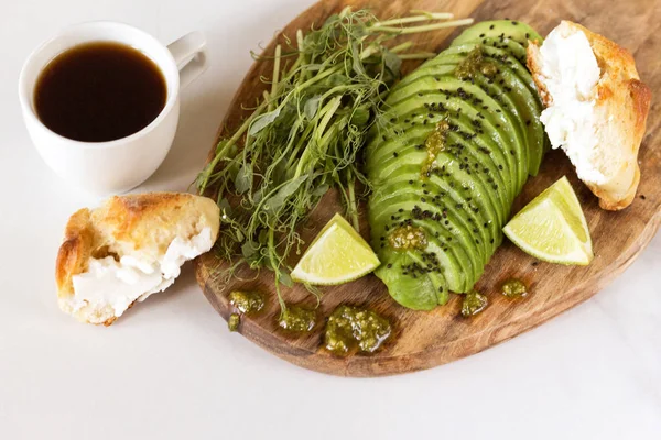 Avokado, topuz, bezelye filizi, limon, pesto ve kahve ile kahvaltı