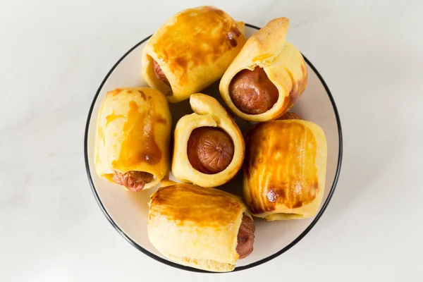 Pastelaria embrulhou rolos de salsicha, tortas de salsicha fritas na massa. Lixo — Fotografia de Stock