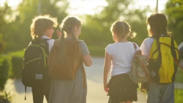 Vier Freunde gehen zur Schule. Sie haben viel Spaß, denn heute ist ihr erster Schultag.. — Stockvideo