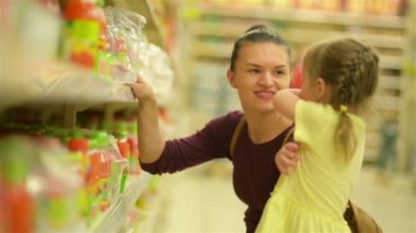 Anne ve kızı suyu süpermarket satın alıyorlar. Süpermarket alışveriş birlikte daha eğlenceli olduğunu.