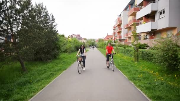 Ritratto di attraente bella coppia in abiti casual Jeans generale Equitazione Retro Biciclette godendo di ciclismo insieme. Si stanno divertendo un sacco. . — Video Stock