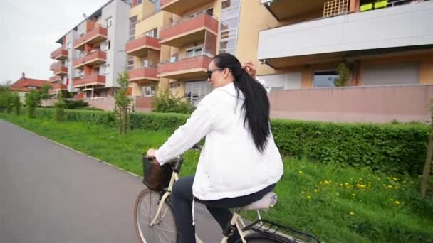 Porträt einer glücklichen jungen Frau auf dem Fahrrad. Sie breitete ihr schönes Haar aus. — Stockvideo