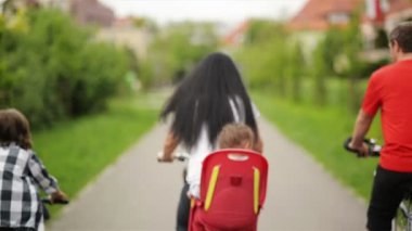 Arka görüş-in bisiklet sürme mutlu bir aile. Onlar eğlenceli bir sürü birlikte sürme olsun.