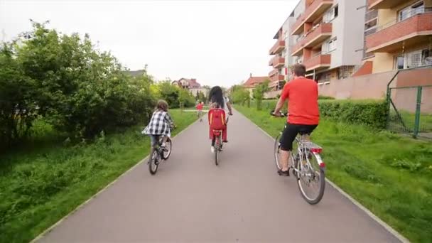 Vista trasera de una familia feliz montar en bicicleta. Se divierten mucho montando juntos . — Vídeos de Stock