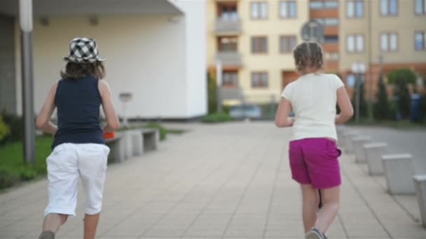 Los niños aprenden a montar scooter en el soleado día de verano. Los niños juegan al aire libre con scooters. Ocio activo y deporte al aire libre para el niño . — Vídeos de Stock