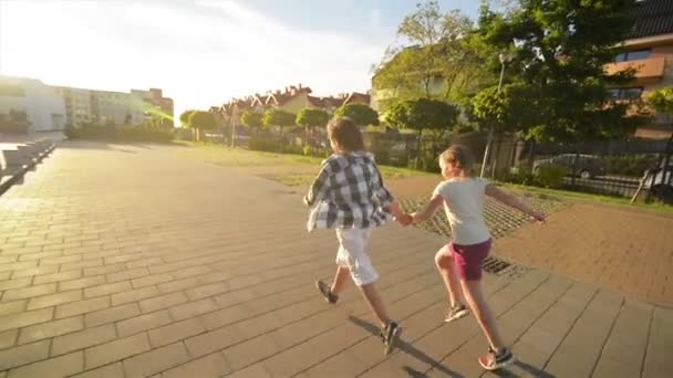 Happy Children Running Together Holding Hands On The Road. Les rayons du soleil brillent dans leurs visages . — Video