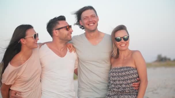 Four People with Wild Toothy Smiles Spending Time Together on the Seaside during Windy Weather and Enjoying the Sunset. — Stock Video