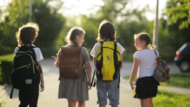 Quatre élèves parlent et marchent en uniforme scolaire . — Video