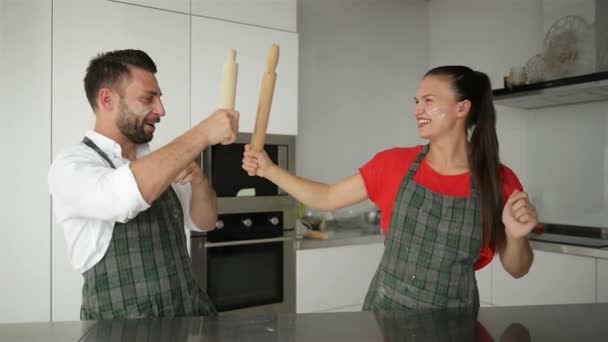 Glückliches Paar hat einen lustigen Kampf auf der Küche. Sie sind gut gelaunt. — Stockvideo