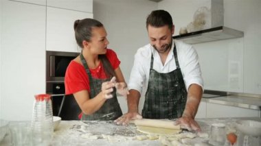 Mutlu çift birlikte mutfakta yemek. Onlar eğlenceli hamur yoğurma ve birbirlerine gülen bir sürü var.