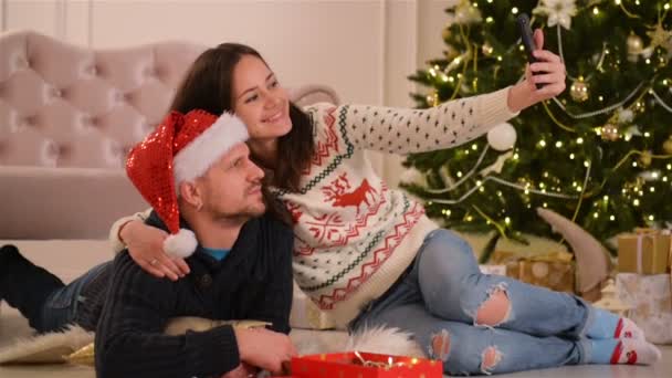 幸せなカップルの肖像画。Selfie をやっている、一緒に笑って。メリー クリスマスと新年あけましておめでとうございます. — ストック動画