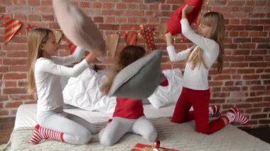 Üçüz kardeşler kılığında içinde pijama yastık kavgası Noel, neşeli Noel ve mutlu yeni yıl için dekore edilmiştir yatağa sahip xmas
