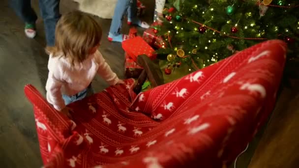 Το χαριτωμένο κοριτσάκι είναι αιώρησης σε μια κουνιστή πολυθρόνα. Ευτυχισμένη οικογένεια δαπανών μαζί την παραμονή των Χριστουγέννων στο τζάκι. Καλά Χριστούγεννα και Ευτυχισμένο το νέο έτος έννοια. — Αρχείο Βίντεο