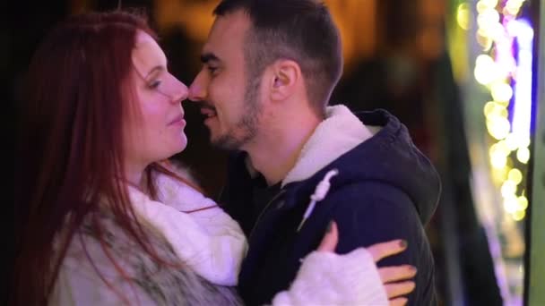 恋人のカップルは一緒にキスします。クリスマス ライトの背景に。良い気分、楽しい、愛、幸せな新年の概念、幸せな家族. — ストック動画