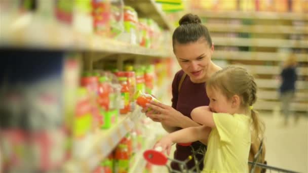 A mãe e a filha estão a comprar sumo no supermercado. Supermercado compras é mais divertido juntos . — Vídeo de Stock