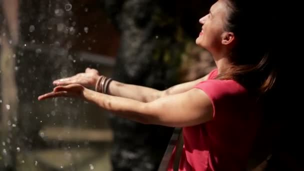 La mujer feliz disfruta de las gotas de agua que caen. El agua es la fuente de la vida . — Vídeo de stock