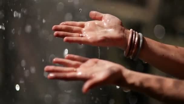 Gotas de gota de água nas mãos das mulheres. Espetáculo Encantador. A água é o motor da vida . — Vídeo de Stock