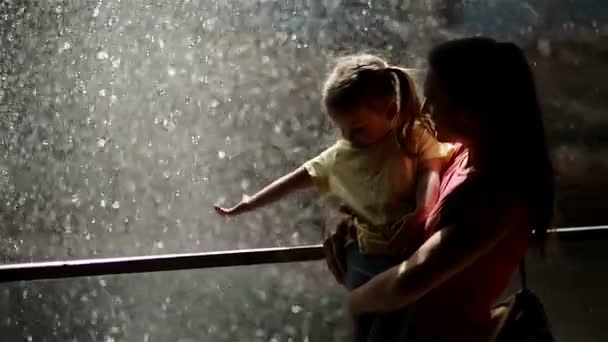 Kvinna med sin dotter som står nära vattenfallet. De är trötta men glada att tillbringa tid tillsammans i naturen. — Stockvideo