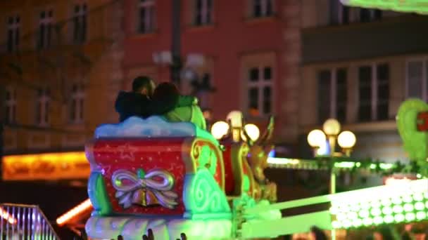 Skrattande par gör Selfie i attraktion på julmarknaden, ung familj skratta i Xmas mässan. God jul och gott nytt år. — Stockvideo