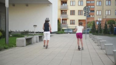 Çocuklar binmek Scooter için güneşli yaz gününde öğrenirler. Çocuklar açık havada scooter ile oynamak. Etkin boş ve çocuk için açık spor.