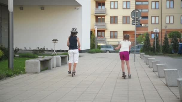 Děti se učí jezdit Scooter slunečného letního dne. Děti hrají venku s koloběžky. Aktivní trávení volného času a venkovní Sport pro děti. — Stock video