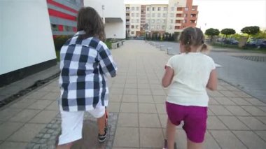 Çocuklar binmek Scooter için güneşli yaz gününde öğrenirler. Çocuklar açık havada scooter ile oynamak. Etkin boş ve çocuk için açık spor.