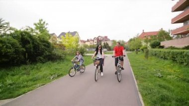 Veliler çocuklarını ile bisiklet sürme vardır. Mutlu aile birlikte vakit.