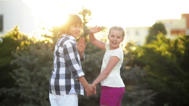 Dos niños retroceden y toman las manos. Retrato de los niños de vuelta en el verano . — Vídeos de Stock