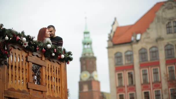 Weihnachten. junges Paar auf dem hölzernen Balkon, der von einem Urlaub geschmückt ist. Romantische Verabredung. — Stockvideo