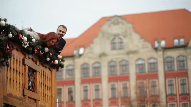 Pár szerelmesek Cuddling magát. Karácsonyi idő alatt áll a fából készült erkéllyel. Boldog új évet koncepció. — Stock videók