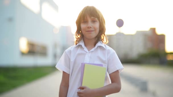 El chico listo sostiene un cuaderno. Está listo para volver a la escuela. Retrato de pupila . — Vídeos de Stock