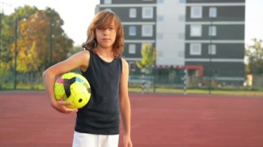 Futbol topu ile genç bir çocuk portresi. Spor kavramı. Futbol oynarken eğlenceli bir yeri vardır.