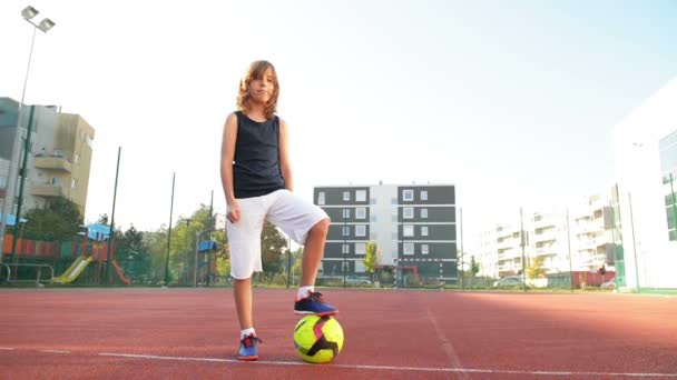 El chico deportivo posando. Sostiene el balón de fútbol. El chico tiene buen humor. Niños, Sonreír, Aire libre, Activo . — Vídeo de stock