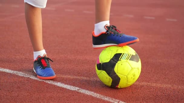 Pelota de fútbol con sus pies chico en el campo de fútbol . — Vídeos de Stock