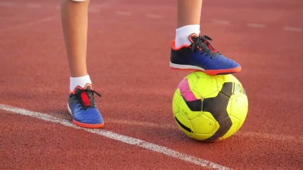 Bola de futebol com seus pés menino no campo de futebol . — Vídeo de Stock