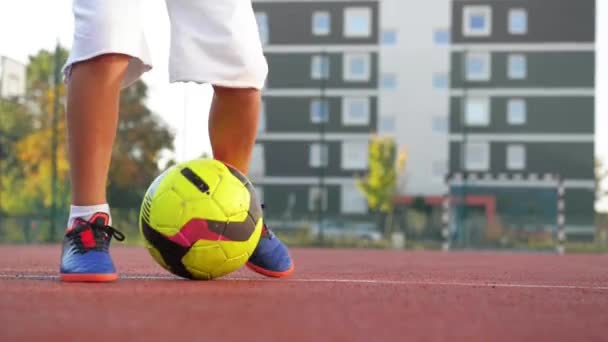 Junge mit kaukasischem Aussehen kickt Fußball im Freien. Er hat viel Spaß beim Fußballspielen. — Stockvideo