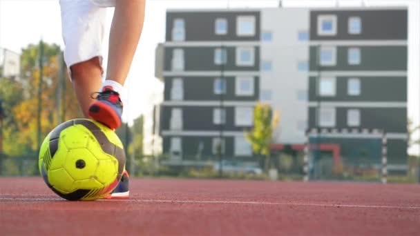 Νεαρό αγοράκι που παίζει στο γήπεδο με μπάλα ποδοσφαίρου. Έννοια του αθλητισμού. — Αρχείο Βίντεο